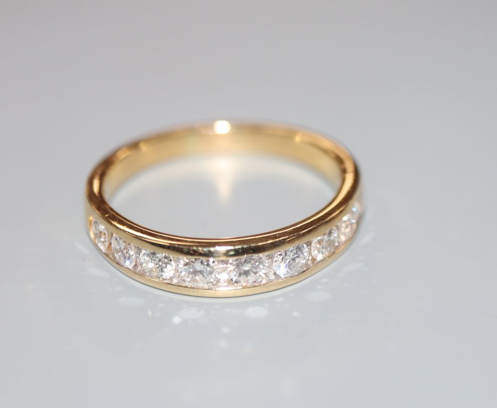 A modern 18ct gold and channel set nine stone diamond half eternity ring